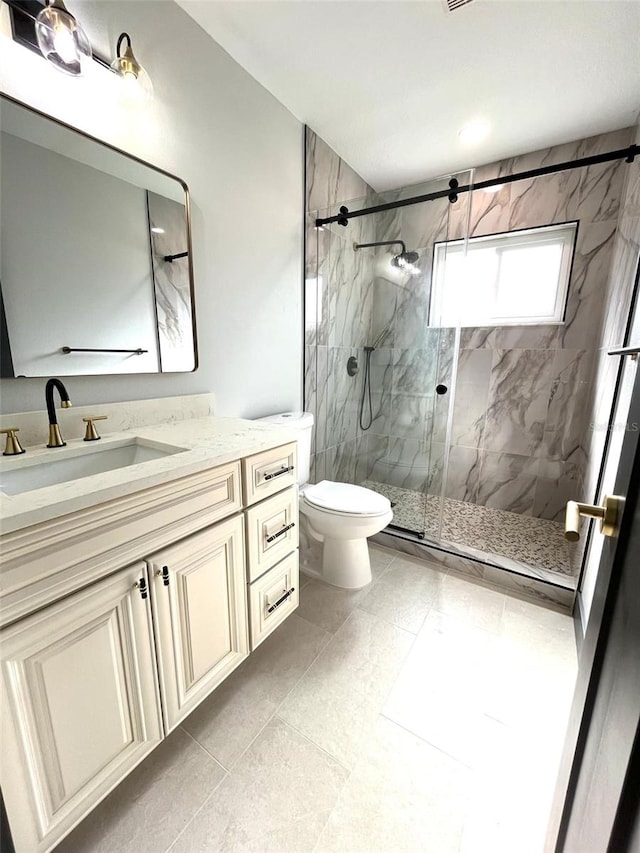 bathroom with tile patterned floors, vanity, toilet, and a shower with shower door