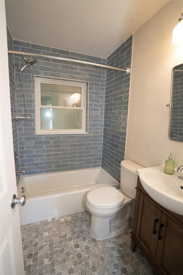 full bathroom with tile patterned floors, vanity, tiled shower / bath combo, and toilet