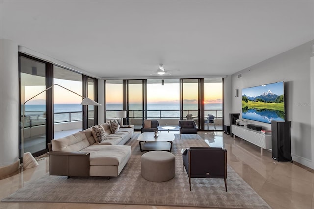 tiled living room with expansive windows, a water view, and ceiling fan