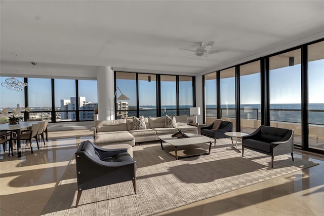 living room featuring expansive windows, ceiling fan, a water view, and light tile patterned floors