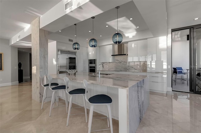 kitchen featuring light stone countertops, appliances with stainless steel finishes, backsplash, pendant lighting, and white cabinets