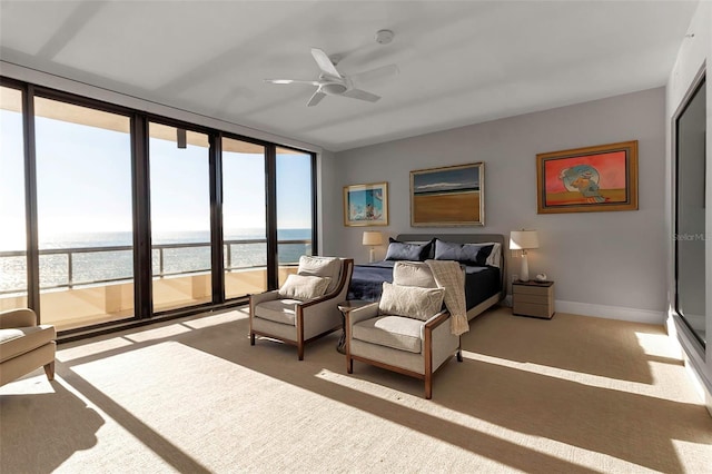 bedroom with access to exterior, a water view, multiple windows, and ceiling fan