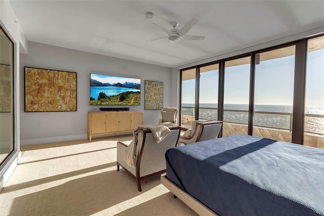 bedroom with ceiling fan, expansive windows, carpet floors, and multiple windows