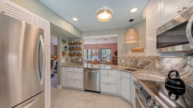 kitchen featuring white cabinets, sink, hanging light fixtures, tasteful backsplash, and stainless steel appliances