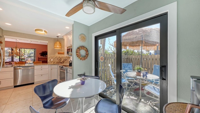 tiled dining space with a mountain view, ceiling fan with notable chandelier, and a healthy amount of sunlight