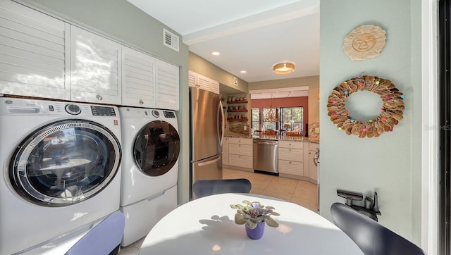 laundry room featuring independent washer and dryer and light tile patterned flooring