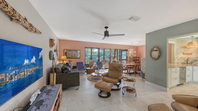 living room featuring light tile patterned floors and ceiling fan with notable chandelier