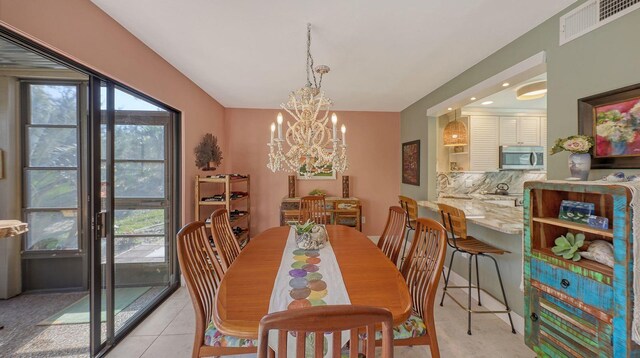 tiled dining area with sink and a chandelier