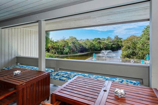 sunroom featuring a water view