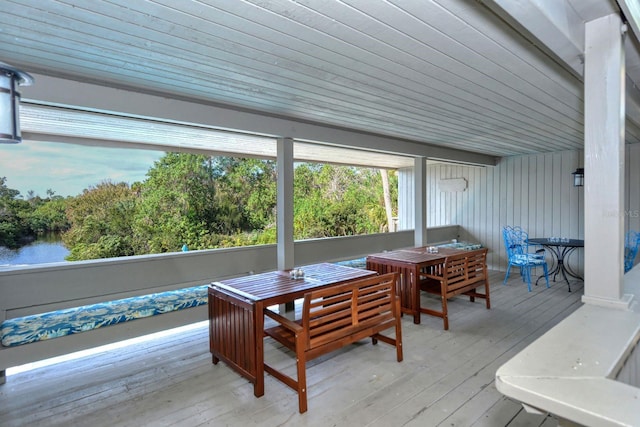 sunroom featuring a water view and wooden ceiling