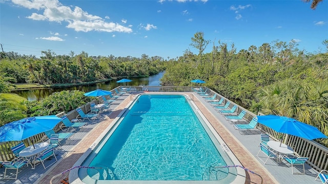 view of pool with a patio area and a water view