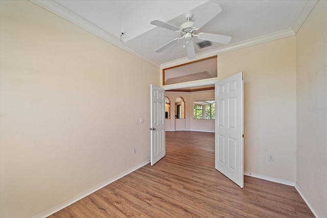 unfurnished room with ceiling fan, wood-type flooring, and crown molding