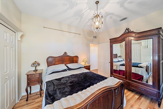 bedroom featuring a closet, a notable chandelier, and light hardwood / wood-style floors