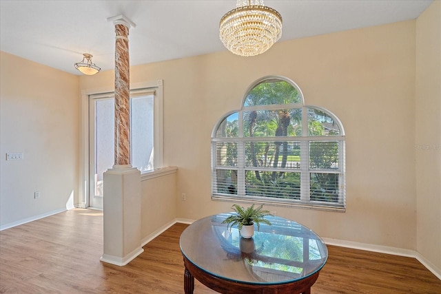 interior space with decorative columns, wood-type flooring, and a chandelier