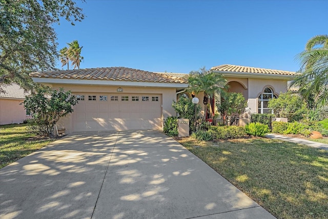 mediterranean / spanish-style house featuring a garage and a front lawn