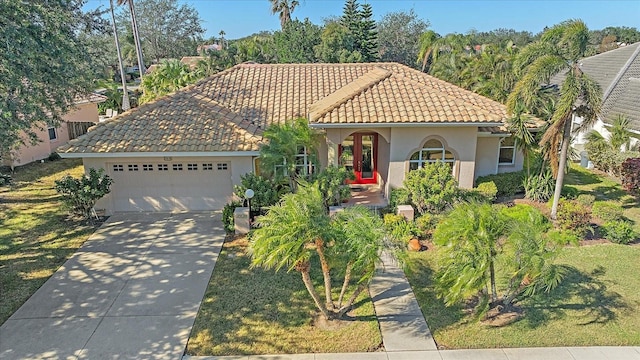 mediterranean / spanish house with a garage and a front lawn