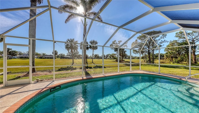 view of pool featuring glass enclosure and a yard