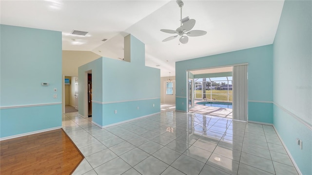 empty room featuring light tile patterned floors, vaulted ceiling, and ceiling fan