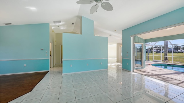 unfurnished room with vaulted ceiling, ceiling fan, and light tile patterned flooring