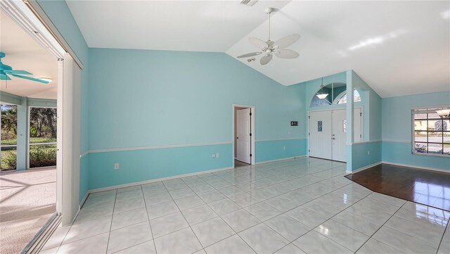 unfurnished room with ceiling fan, light tile patterned floors, and vaulted ceiling