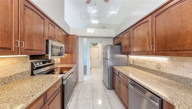 42 Marker Rd, Rotonda West, FL 33947 - kitchen with stainless steel appliances, tasteful backsplash, light stone countertops, and light tile patterned flooring