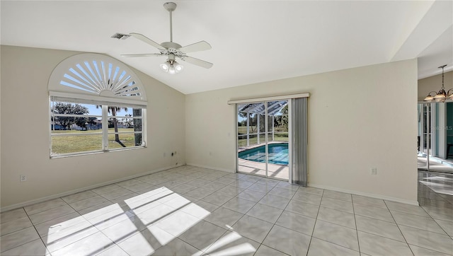 unfurnished room featuring light tile patterned floors, ceiling fan with notable chandelier, and lofted ceiling