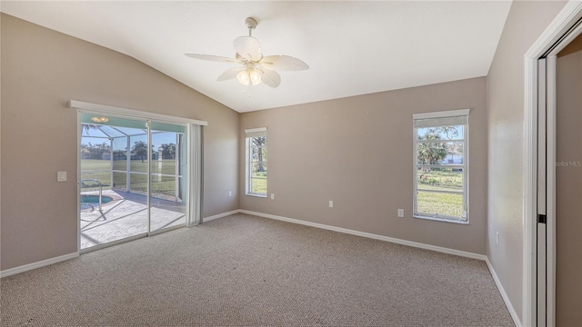 carpeted empty room with ceiling fan and lofted ceiling