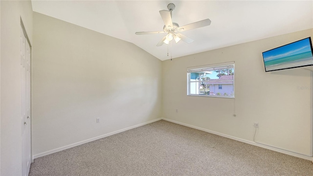 empty room featuring carpet, ceiling fan, and vaulted ceiling