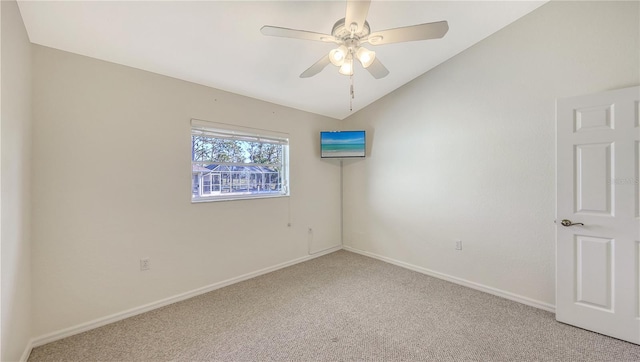 carpeted spare room with ceiling fan and lofted ceiling