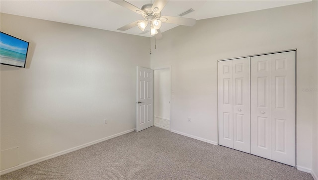 unfurnished bedroom featuring light carpet, a closet, and ceiling fan