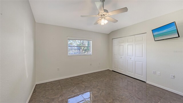 unfurnished bedroom featuring ceiling fan, a closet, and lofted ceiling