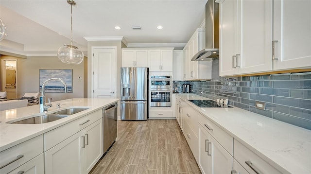 kitchen featuring white cabinets, light hardwood / wood-style flooring, wall chimney exhaust hood, appliances with stainless steel finishes, and light stone counters