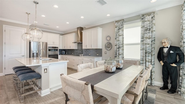 dining space featuring light wood-type flooring and crown molding