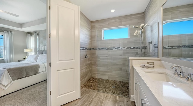 bathroom featuring plenty of natural light, vanity, and tiled shower