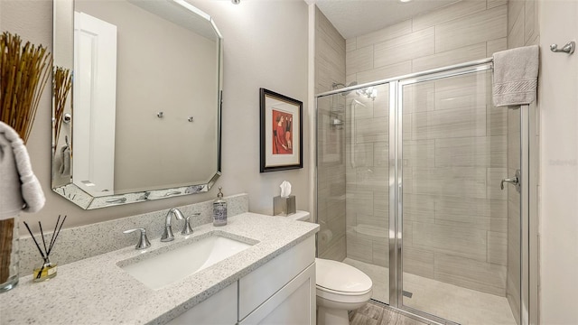 bathroom with vanity, an enclosed shower, and toilet