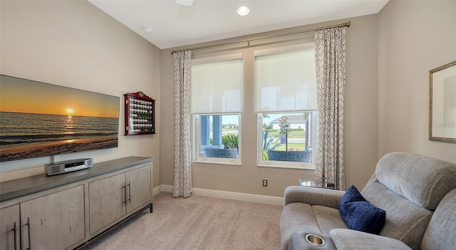 sitting room with light carpet and vaulted ceiling