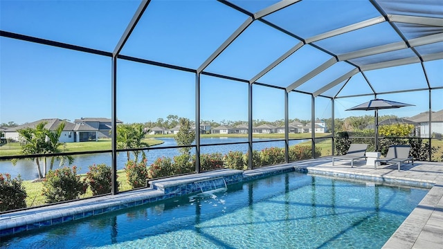 view of swimming pool featuring a patio, pool water feature, a water view, and glass enclosure