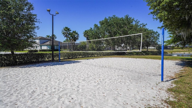 surrounding community with a water view and volleyball court