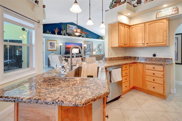 kitchen with light brown cabinetry, stainless steel dishwasher, sink, pendant lighting, and lofted ceiling