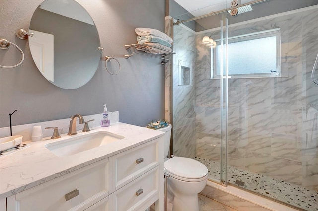 bathroom featuring vanity, toilet, and a shower with shower door