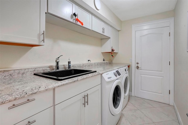 laundry area featuring washer and clothes dryer, sink, and cabinets