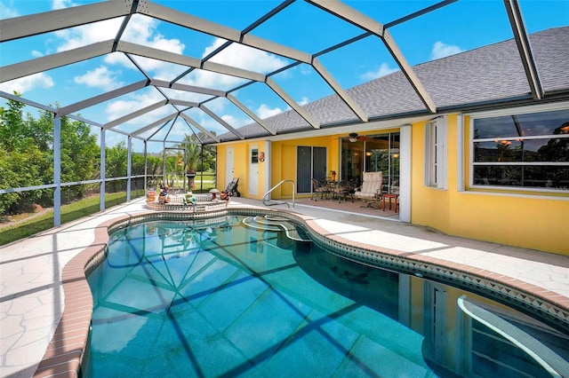 view of swimming pool with glass enclosure, ceiling fan, and a patio