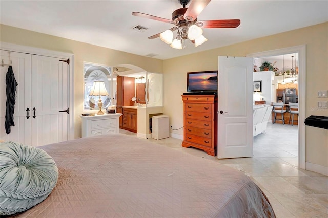 tiled bedroom featuring ensuite bath and ceiling fan