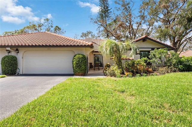 mediterranean / spanish-style house featuring a front lawn and a garage