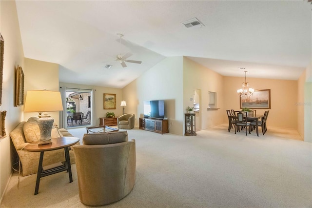 carpeted living room with ceiling fan with notable chandelier and vaulted ceiling