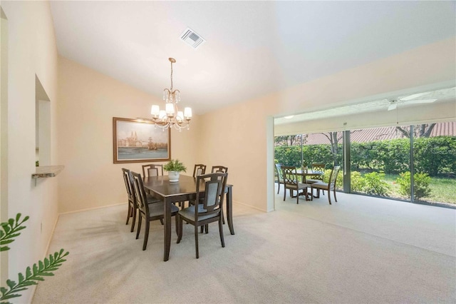 carpeted dining space featuring ceiling fan with notable chandelier and lofted ceiling