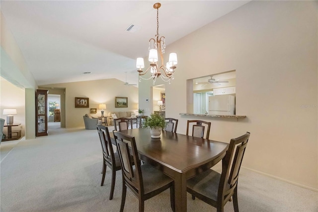 carpeted dining room featuring ceiling fan with notable chandelier and lofted ceiling