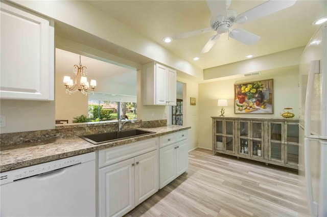 kitchen featuring white appliances, white cabinets, ceiling fan with notable chandelier, sink, and light hardwood / wood-style floors