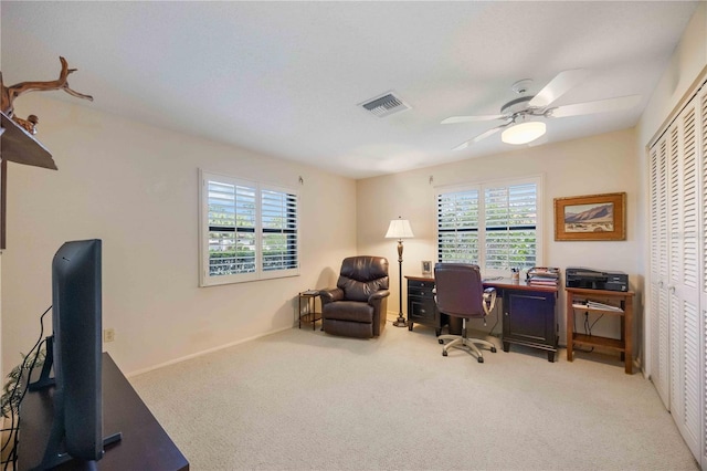 carpeted office space with ceiling fan