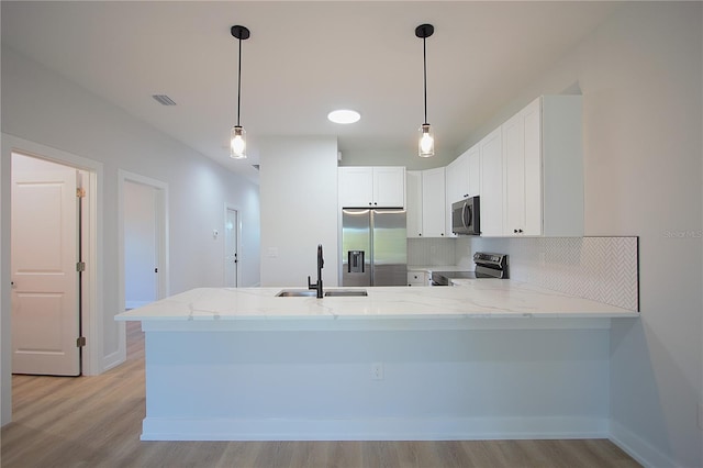 6779 David Blvd, Port Charlotte, FL 33981 - kitchen with stainless steel appliances, light stone countertops, a peninsula, light wood-style floors, and backsplash